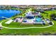 Aerial shot of a community pool and recreational area surrounded by lush landscaping and a beautiful lake at 15469 Shorebird Ln, Winter Garden, FL 34787