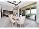 Dining area with dark wood trim ceiling detail, sliding glass doors, view to the outdoor kitchen and pool at 15469 Shorebird Ln, Winter Garden, FL 34787