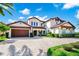 Elegant two-story home with a red tile roof, arched entryway, and well-manicured front yard at 15469 Shorebird Ln, Winter Garden, FL 34787