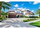 Stunning two-story home boasts a beautiful red tile roof, lush landscaping, and a paver driveway at 15469 Shorebird Ln, Winter Garden, FL 34787