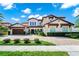 Attractive two-story home with a red tile roof, attached garage, and manicured landscaping at 15469 Shorebird Ln, Winter Garden, FL 34787