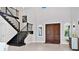 Grand foyer with soaring ceilings, dark wood staircase, and double front doors filled with natural light at 15469 Shorebird Ln, Winter Garden, FL 34787