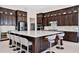 Kitchen with center island featuring seating, dark wood cabinets, stainless steel appliances, and granite countertops at 15469 Shorebird Ln, Winter Garden, FL 34787