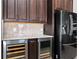 Kitchen features wine coolers, granite counters, stainless refrigerator and dark wood cabinets at 15469 Shorebird Ln, Winter Garden, FL 34787