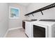 Functional laundry room with modern washer and dryer, window, and storage space at 15469 Shorebird Ln, Winter Garden, FL 34787