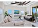 Living room features elegant tray ceiling, large windows, and comfortable seating area at 15469 Shorebird Ln, Winter Garden, FL 34787