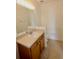 Well-lit bathroom featuring a single sink vanity and a large mirror at 17519 Blessing Dr, Clermont, FL 34714