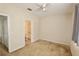 This carpeted bedroom leads to an en-suite bathroom with a ceiling fan at 17519 Blessing Dr, Clermont, FL 34714