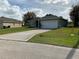 A cozy single-story home with a long driveway and a two-car garage at 1958 Sawfish Dr, Kissimmee, FL 34759