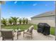 Backyard patio with seating and grill, overlooking fenced yard with palm trees at 2091 Brillante Dr, St Cloud, FL 34771
