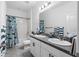 Bright bathroom with double sinks, white cabinets, shower-tub combo with blue shark shower curtain at 2091 Brillante Dr, St Cloud, FL 34771