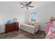 Brightly lit bedroom with a single bed, floral bedding, window, ceiling fan, and dark wood dresser at 2091 Brillante Dr, St Cloud, FL 34771
