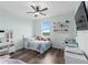 Colorful bedroom featuring a twin bed, desk, shelves, a ceiling fan, hardwood floors, and a bright window at 2091 Brillante Dr, St Cloud, FL 34771
