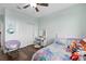 Bright bedroom with dark floors, closet, ceiling fan, and a vibrant bed with fun decor at 2091 Brillante Dr, St Cloud, FL 34771