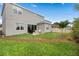 Back exterior view of a modern two-story home, featuring a backyard, patio, and lush green grass at 2091 Brillante Dr, St Cloud, FL 34771