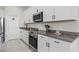 Modern kitchen with stainless steel appliances, granite countertops, and sleek white cabinetry at 2091 Brillante Dr, St Cloud, FL 34771