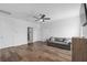 Cozy living room with hardwood floors, a gray sofa, a ceiling fan, and doors leading to other rooms at 2091 Brillante Dr, St Cloud, FL 34771