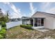 Enjoy this home's backyard featuring a screened-in patio, grassy area, and a white fence for privacy and security at 2209 Hannah Ln, Orlando, FL 32826