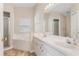 Bright bathroom with double sinks, framed mirror, tub, and glass-enclosed shower at 2209 Hannah Ln, Orlando, FL 32826