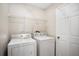 Convenient laundry room equipped with a washer, dryer, and ample shelving for storage at 2209 Hannah Ln, Orlando, FL 32826