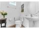 Clean half bathroom featuring a pedestal sink, white toilet, and decorative wall art, offering a fresh and functional space at 2246 Rush Bay Way, Orlando, FL 32824