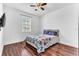 Well-lit bedroom with hardwood floors, ceiling fan, window and a cozy floral bedspread at 2246 Rush Bay Way, Orlando, FL 32824