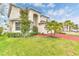 Exterior view of a well maintained two-story home with lush landscaping and a red driveway at 2246 Rush Bay Way, Orlando, FL 32824