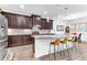 Kitchen showcasing dark wood cabinets, granite countertops, stainless steel appliances, and a center island with seating at 2246 Rush Bay Way, Orlando, FL 32824