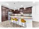 Spacious kitchen featuring granite counters, dark wood cabinetry, stainless steel appliances, and seating at the island at 2246 Rush Bay Way, Orlando, FL 32824