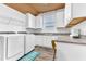 Well-organized laundry room featuring white cabinets, granite countertops, and modern washer and dryer units for efficient chores at 2246 Rush Bay Way, Orlando, FL 32824