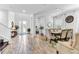 Open-concept living area with wood-look tile, staircase, dining area, and views of the backyard through bright windows at 2246 Rush Bay Way, Orlando, FL 32824