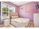 Charming bedroom with a comfortable bed, bright window and playful cartoon wall decor at 2318 Silver Palm Dr, Kissimmee, FL 34747