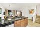 Open kitchen with granite countertops, island sink, and dining area next to a staircase at 2647 Corvette Ln, Kissimmee, FL 34746