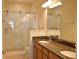 Bathroom featuring double sinks, granite counters, and a glass-enclosed shower with pebble floor at 2657 Youngford St, Orlando, FL 32824