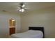 Bedroom with ceiling fan and view into a bathroom with granite counters and wood cabinets at 2657 Youngford St, Orlando, FL 32824