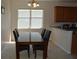 Cozy dining area featuring a glass-top table with black chairs and a large window with natural light at 2657 Youngford St, Orlando, FL 32824