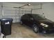 Garage containing a black car, a garage door, and a recycling bin at 2657 Youngford St, Orlando, FL 32824