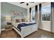 Bright bedroom with wood floors, white trim, blue accent wall, and bright windows at 2925 Caribbean Soul Dr, Kissimmee, FL 34747