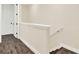 A hallway with neutral walls and wood floors next to stairs at 2925 Caribbean Soul Dr, Kissimmee, FL 34747