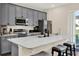 Modern kitchen with stainless steel appliances, gray cabinetry, a breakfast bar and stylish countertops at 2925 Caribbean Soul Dr, Kissimmee, FL 34747