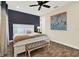 Comfortable main bedroom featuring wood floors, a ceiling fan, and a blue accent wall at 2925 Caribbean Soul Dr, Kissimmee, FL 34747