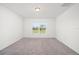 Neutral-toned bedroom with carpet flooring, a ceiling light, and a large window offering plenty of light at 3201 Sweet Acres Pl, St Cloud, FL 34772