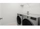 Modern laundry room with front loading washer and dryer, plus a wire shelf for storage at 3201 Sweet Acres Pl, St Cloud, FL 34772