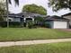 Charming blue single-story home with well-manicured lawn, trimmed shrubs and solar panels at 4024 Lillian Hall Ln, Orlando, FL 32812