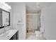 Bright bathroom featuring a dark vanity, white walls, framed mirror, and a glass-enclosed shower at 4086 Biscayne Ct, Casselberry, FL 32707