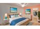 Cozy bedroom with coastal decor, featuring a wicker bed frame, blue accents, and relaxing beach artwork at 4086 Biscayne Ct, Casselberry, FL 32707