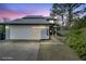 Two-story home featuring a gray exterior, dark roof, and a modern garage door with horizontal window accents at 4086 Biscayne Ct, Casselberry, FL 32707