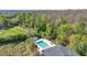 Aerial view of community pool surrounded by lush landscaping and bordering a protected nature preserve at 4431 Le Reve Ct, Kissimmee, FL 34746