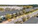 Aerial view of new townhomes with a street lined with mature trees near a large commercial building at 4431 Le Reve Ct, Kissimmee, FL 34746