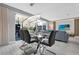 Dining area with a glass table and sleek chairs, adjacent to a living room and patio, ideal for gatherings at 4431 Le Reve Ct, Kissimmee, FL 34746